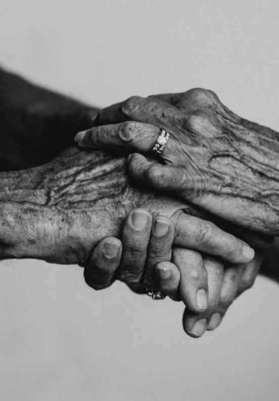 Two pairs of hands holding on to each other, one older than the other.